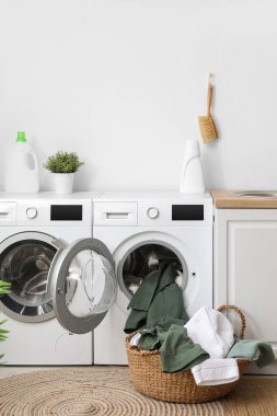 Çamaşır odasında kirli çamaşırları olan modern çamaşır makineleri.