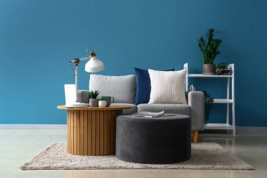 İçinde sehpa, puf ve kanepe olan modern oturma odası.