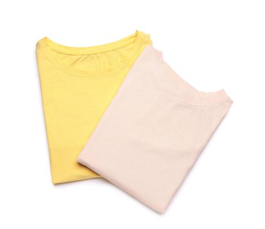 Beyaz arkaplanda katlanmış sarı ve pembe tişörtler