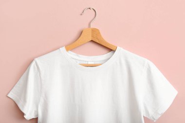Pembe duvarda asılı beyaz tişört