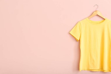 Pembe duvarda asılı sarı tişört