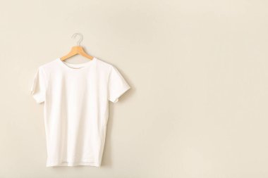 Gri duvarda asılı beyaz tişört