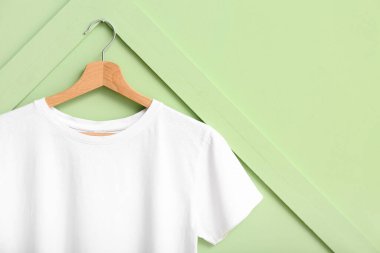 Yeşil duvarda asılı beyaz tişört
