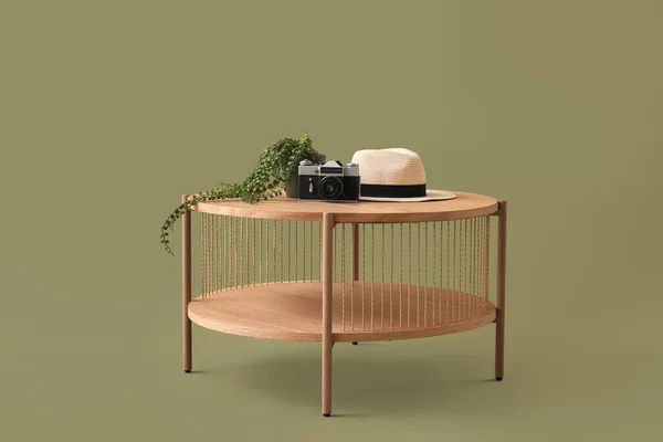 Holztisch Mit Kamera Hut Und Zimmerpflanze Auf Grünem Hintergrund — Stockfoto