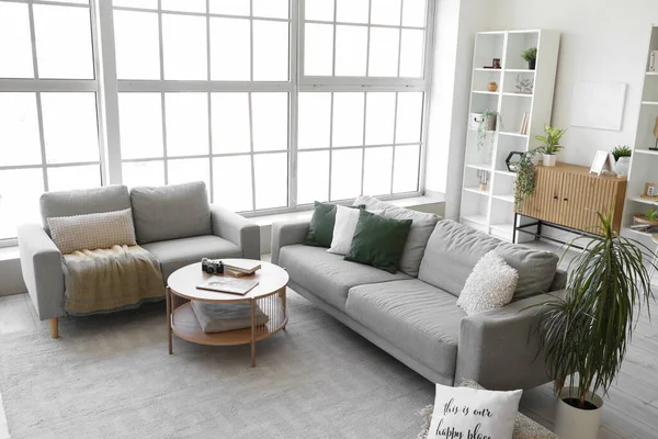 居心地の良いグレーのソファとコーヒーテーブル付きの明るいリビングルームのインテリア — ストック写真