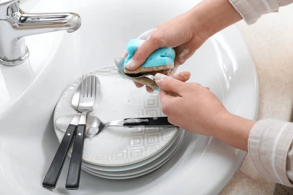 stock image Woman washing spoon with sponge in sink, closeup