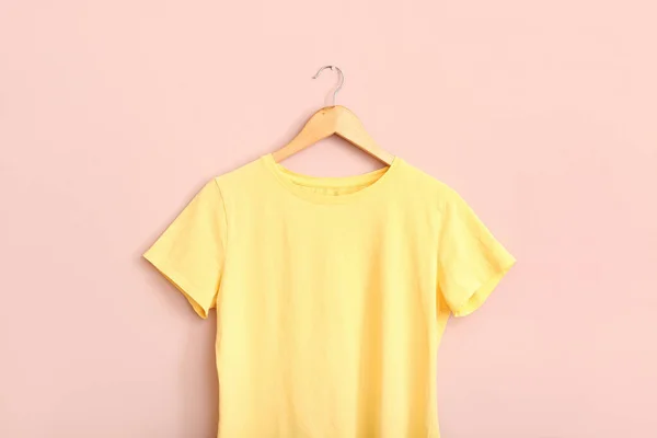 Yellow t-shirt hanging on pink wall