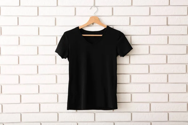 Zwart Shirt Hangend Aan Witte Bakstenen Muur — Stockfoto