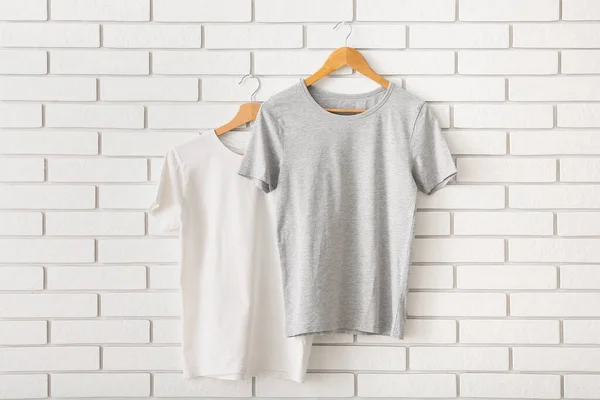 Stijlvolle Shirts Hangend Aan Witte Bakstenen Muur — Stockfoto