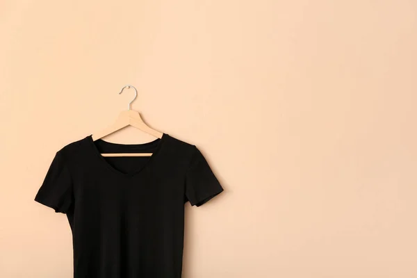 Black t-shirt hanging on light wall