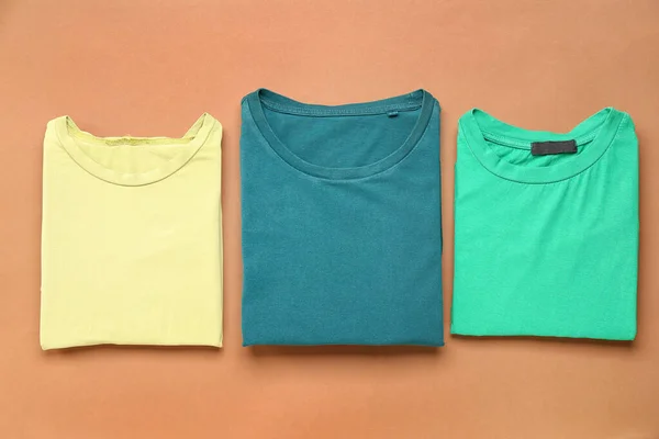 Folded t-shirts on brown background