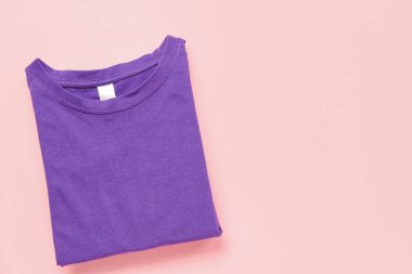 Pembe arkaplanda katlanmış mor tişört