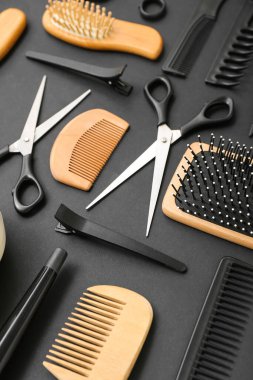 Siyah arka planda kuaför aksesuarları olan kompozisyon, yakın plan.