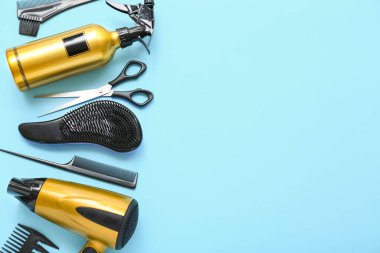 Mavi arka planda kuaför aksesuarları ve kurutma makinesi olan kompozisyon