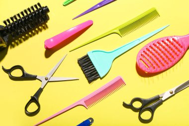 Sarı arka planda kuaför aksesuarları olan kompozisyon
