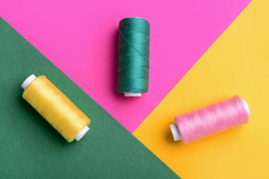 Renk arkaplan üzerinde iplik makaraları kümesi