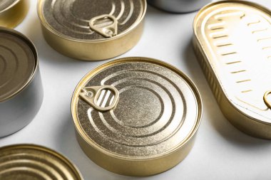 Beyaz arka planda balık bulunan teneke kutular.