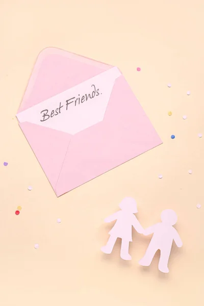 人の手と封筒付きギフトカード付き友情の日のためにベージュの背景 — ストック写真