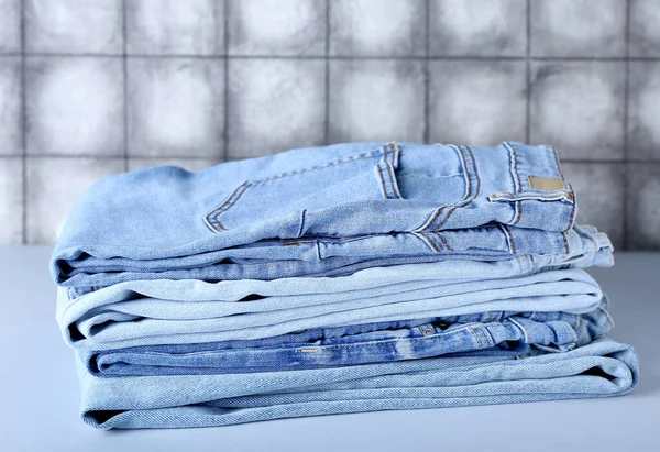 Pila Jeans Mesa Cerca Pared Baldosas Grises —  Fotos de Stock