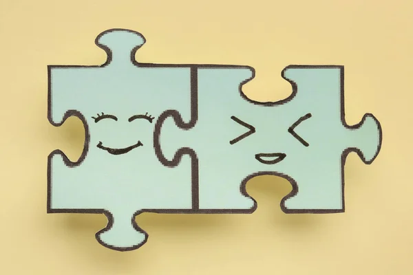 Puzzle pieces with happy faces on beige background. Friendship Day celebration