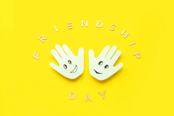 黄色の背景に幸せな顔とテキストの友情の日のヤシ — ストック写真