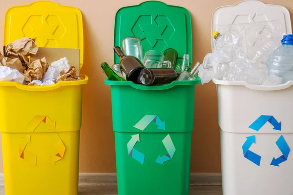 リサイクルシンボルとベージュの壁の近くに別のゴミとゴミ箱 — ストック写真