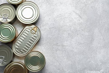 Gri masadaki balıklı teneke kutular.