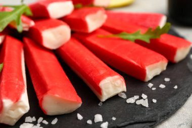 Masada lezzetli yengeç çubukları olan tahta, yakın plan.