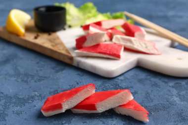 Mavi arka planda lezzetli kesilmiş yengeç çubukları