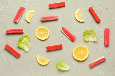 Lezzetli yengeç çubukları, arkaplanda limon dilimleri ve marul.