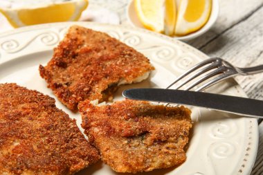 Hafif ahşap arka planda kızarmış morina balığı tabağı, yakın plan.