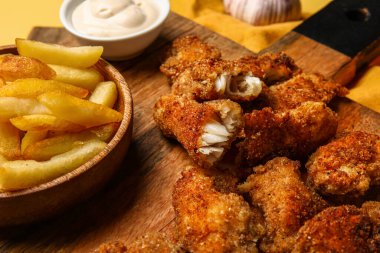 Tahta tahtada kızarmış morina balığı ve patates kızartması var. Yakın plan.