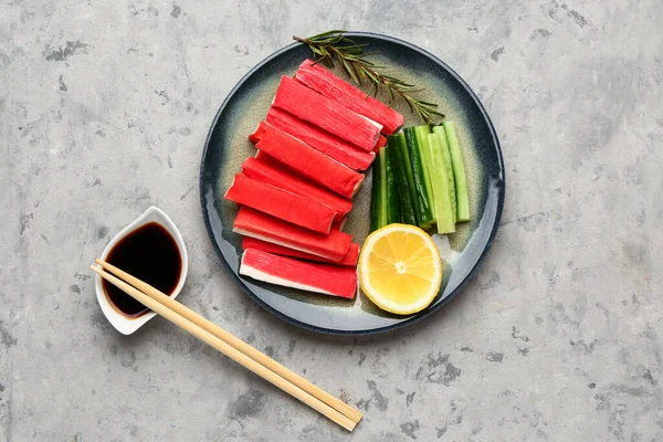 Stock image Plate with tasty crab sticks and sauce on grunge background