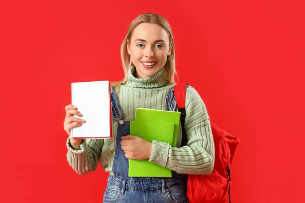 Vrouwelijke Student Met Notitieboekjes Rode Achtergrond — Stockfoto