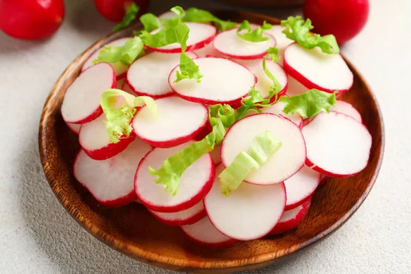 stock image Bowl with fresh slices of radish and lettuce on white background