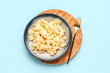 Çırpılmış yumurta tabağı ve açık mavi arka planda otlar.