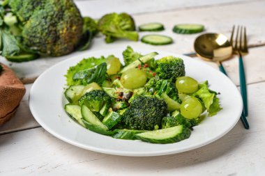 Beyaz tahta arka planda sebzeli bir tabak salata.