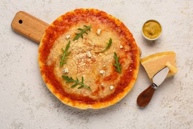 Parmesan peynirli ve bıçaklı ahşap bir pizza tahtası.