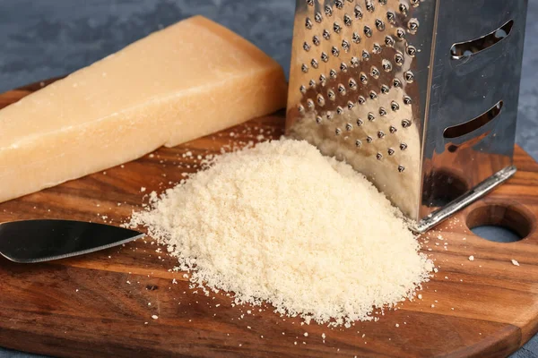 Wooden Board Tasty Grated Parmesan Cheese Blue Background Closeup — Stock Photo, Image