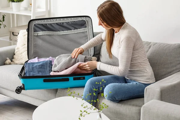 若いです女性Unpacking彼女の服からスーツケースで自宅 — ストック写真