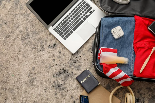 彩色地毯上装有男装 手提电脑和旅行配件的手提箱 — 图库照片