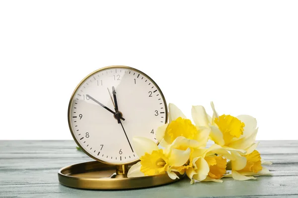 白い背景を持つテーブルの上の黄色の水仙と時計 — ストック写真