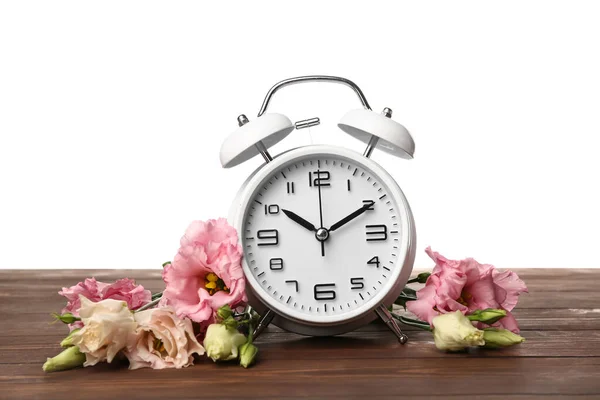 白い背景を背景にしたテーブルの上の花や目覚まし時計 — ストック写真