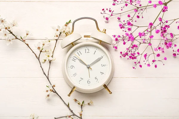 春の枝や白い木製の背景に白い目覚まし時計を開花 — ストック写真