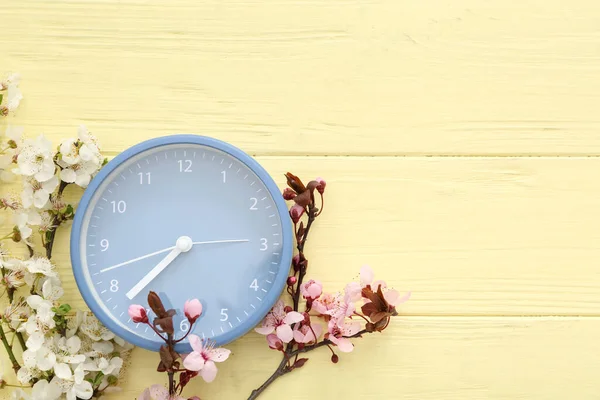 Kwitnące Gałęzie Wiosny Niebieski Zegar Żółtym Drewnianym Tle — Zdjęcie stockowe