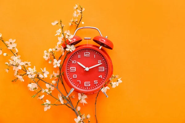 Квітучі Весняні Гілки Червоний Будильник Помаранчевому Фоні — стокове фото