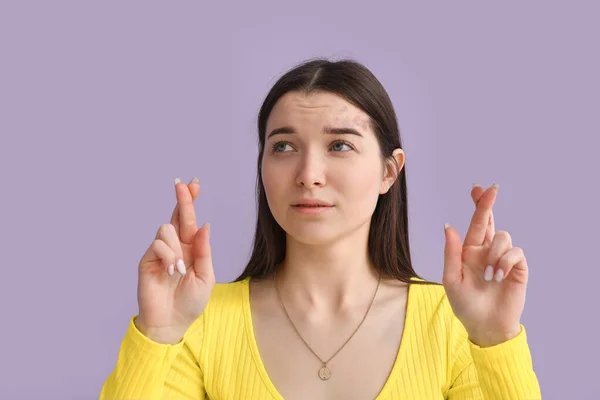 穿着亮丽衬衫的年轻女子在紫丁香背景上交叉手指 — 图库照片