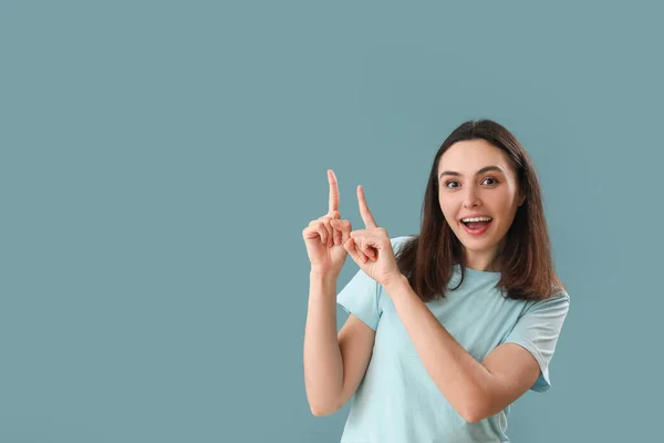 Young Woman Pointing Something Blue Background — Stock Photo, Image