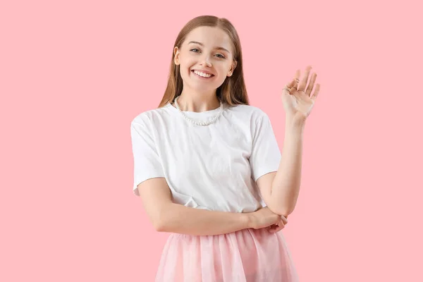 Junge Frau Shirt Wedelt Mit Der Hand Auf Rosa Hintergrund — Stockfoto