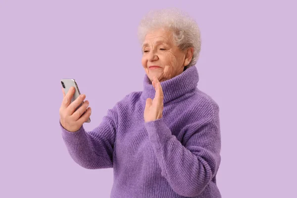 Starsza Kobieta Wideo Telefonu Komórkowego Czacie Tle Liliowym — Zdjęcie stockowe